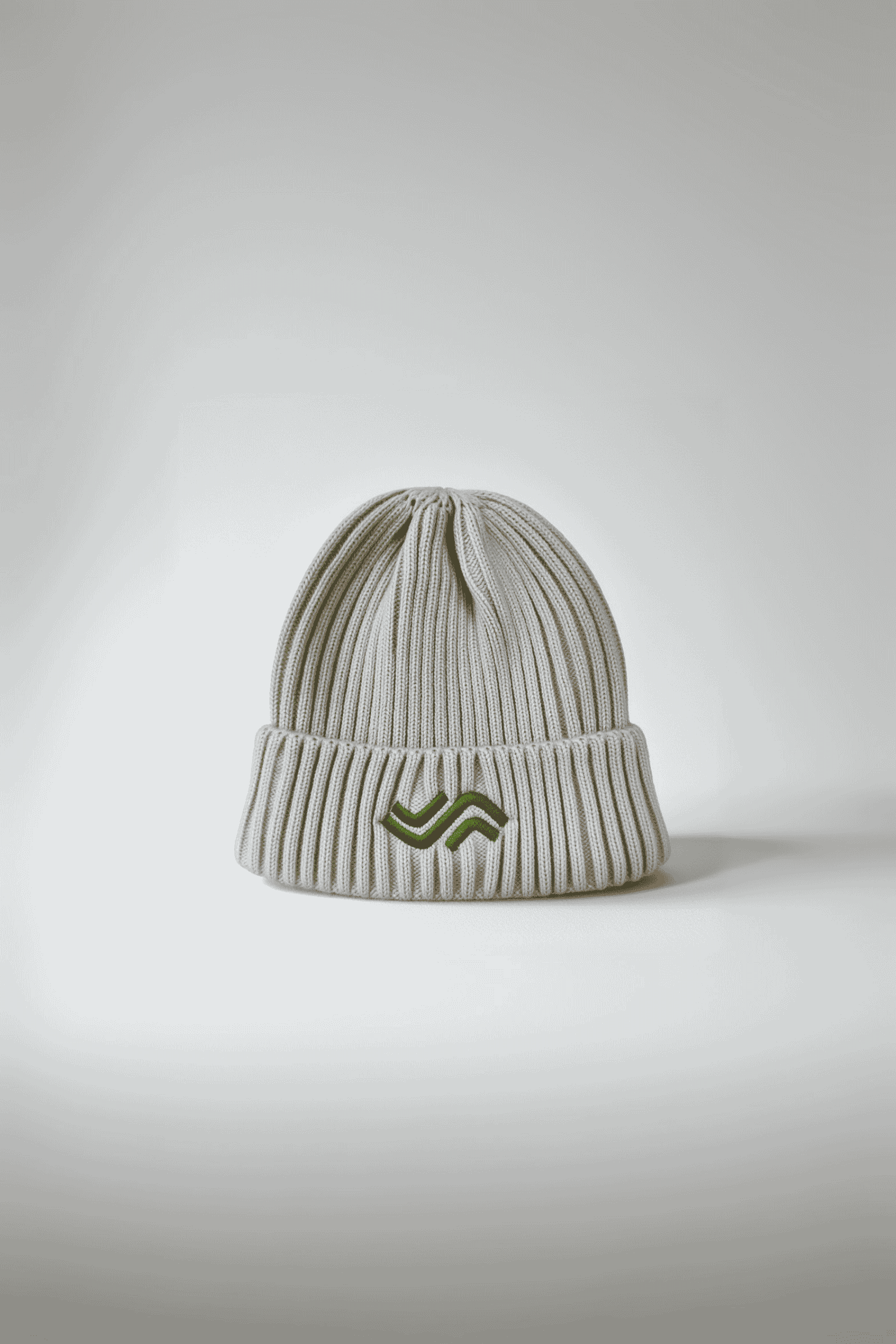 White knit beanie with a logo on a light gray background