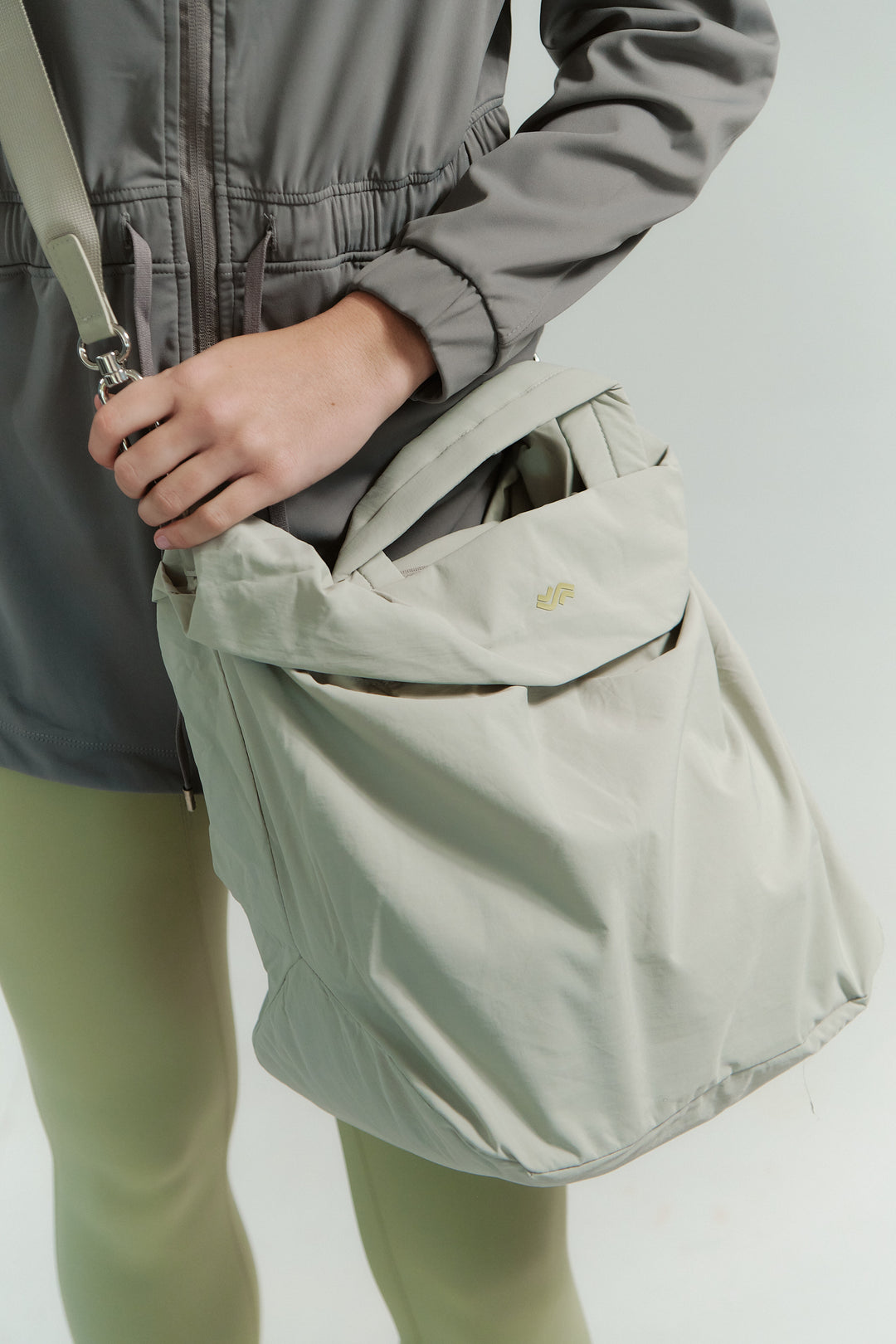 Person holding a beige bag with a plain background