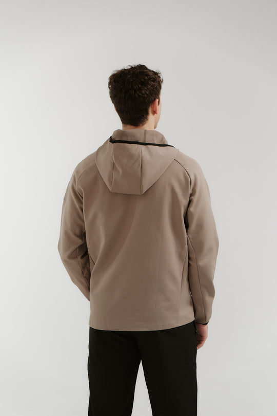 Person wearing a beige jacket with a hood on a white background